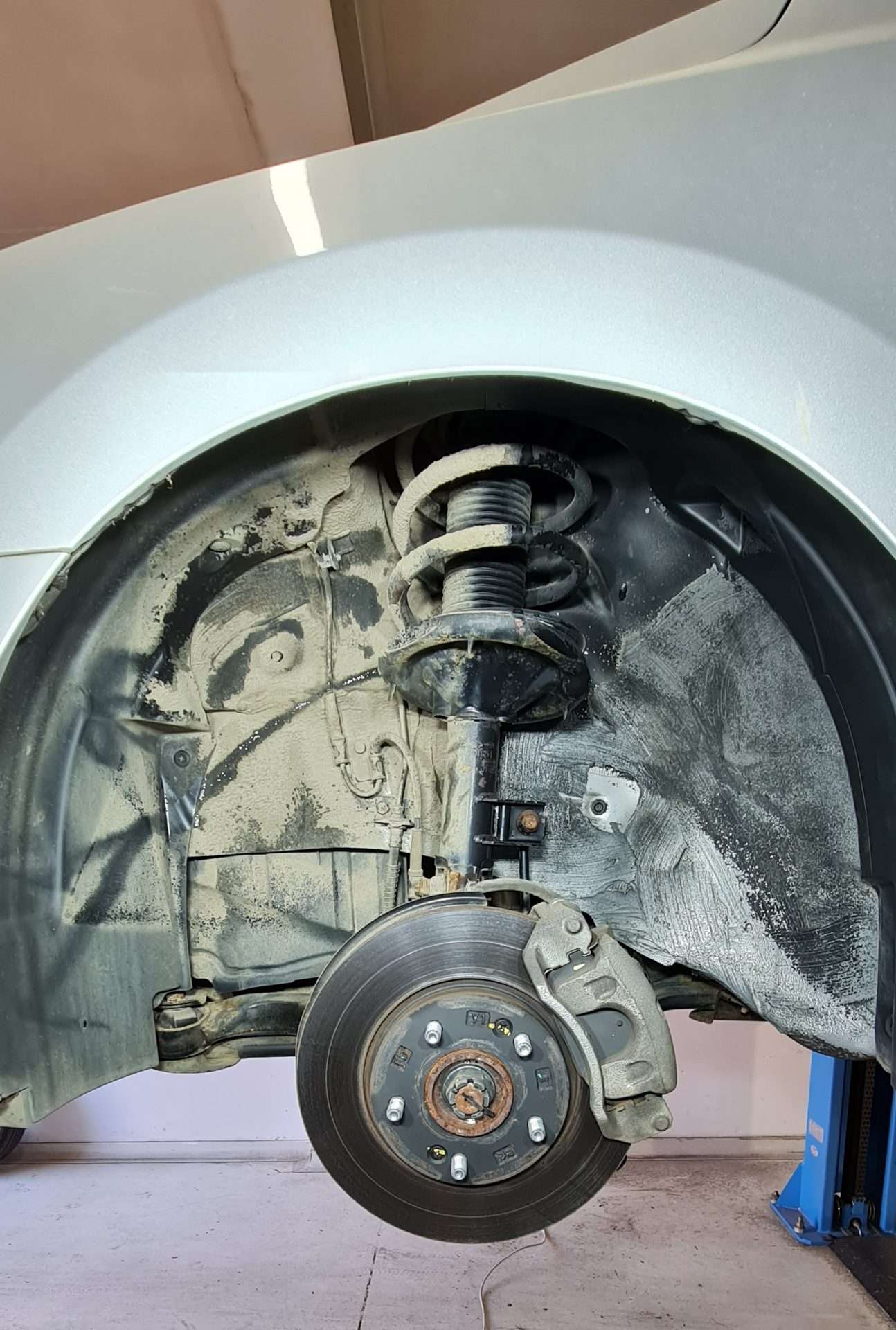 Wheel arch interior showing suspension strut and brake disc cleaned by dry ice blasting — automotive service by ICEBLASTER Melbourne